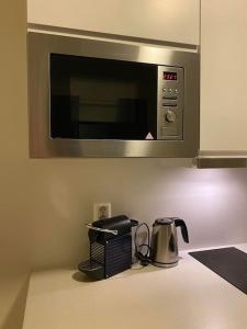 a kitchen counter with a toaster and a microwave at Modern studio apartment in fantastic nature in Tromsø