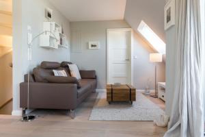 ein Wohnzimmer mit einem braunen Sofa und einem Tisch in der Unterkunft Fewo Wohnen und Mee(h)r, App. 2 in Wenningstedt-Braderup