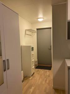 an empty room with a refrigerator and a door at Modern studio apartment in fantastic nature in Tromsø