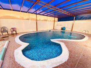 a large swimming pool in a building at Holiday Home Rent villa in Sharjah