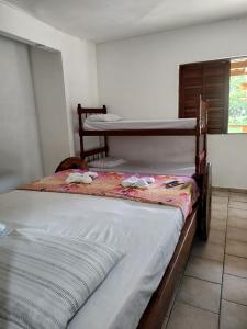 two bunk beds in a room with a window at Pousada Rancho Texas Ubatuba in Ubatuba