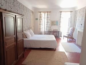 Le Mas Palegry Chambres d'hôtes Perpignan في بيربينيا: غرفة نوم فيها سرير وخزانة