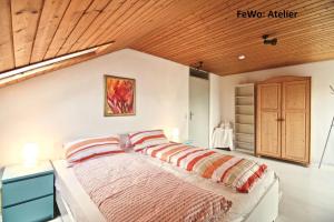 1 dormitorio con 1 cama con 2 almohadas en Atelierwohnung mit Seeblick, en Sipplingen