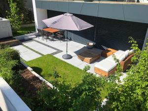 a patio with an umbrella and a table and chairs at seenahe Design-Ferienwohnung Loft Aquamarin in Überlingen