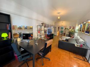 a living room with a table and chairs and a couch at Spacious Artistic Flat With Private Parking in Thessaloniki