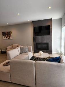 a living room with two couches and a fireplace at Cozy Gems of Kensington in Calgary