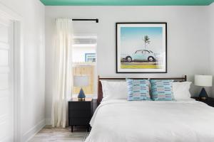 sypialnia z białym łóżkiem i zdjęciem samochodu w obiekcie Magic Hour w mieście St. Augustine
