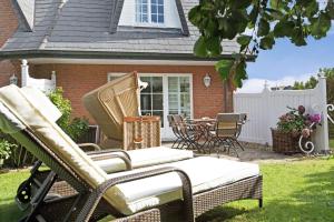 a patio with chairs and a table in a yard at SYLThouse in Wenningstedt