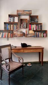a black cat laying on a desk with a chair at Casa Nonada in São João del Rei