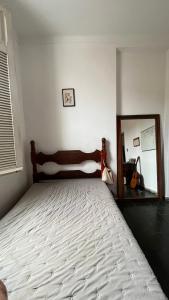 a bedroom with a large bed and a mirror at Casa Nonada in São João del Rei