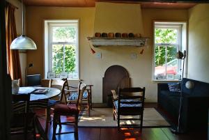 een woonkamer met een tafel en een open haard bij De Leemstee, Authentieke boerderij met modern comfort in Eext