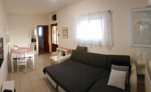 ein Wohnzimmer mit einem Sofa und einem Tisch in der Unterkunft Apartmani Ela in Prvić Luka