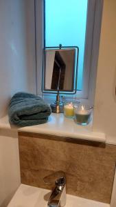 a bathroom sink with a mirror and candles on a counter at Cosy cottage in picturesque Hawkshead in Hawkshead