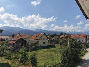 un village avec des maisons et des montagnes en arrière-plan dans l'établissement RADEIA Govedartsi РАДЕЯ Говедарци, à Govedartsi