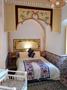 a bedroom with a large bed with a floral headboard at Dar Baaziz 3 in Sousse