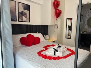 Una cama con dos corazones rojos y dos globos. en Conforto e segurança na avenida Liberdade, en São Paulo