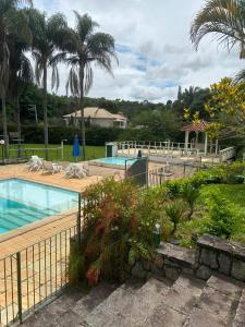 Blick auf einen Pool mit Palmen in der Unterkunft Apart em Miguel Pereira in Miguel Pereira