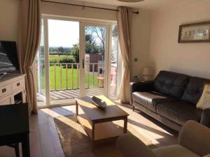 a living room with a couch and a table at The Cottage in Baxterley. Peaceful home from home. Beautifully finished. in Baxterley