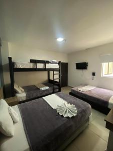 a room with two bunk beds and a television at Hotel America 52 in Rionegro