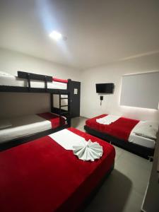a bedroom with two bunk beds and a red blanket at Hotel America 52 in Rionegro