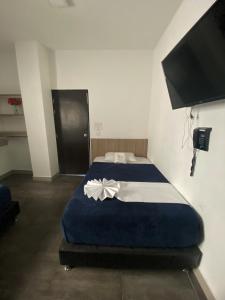 Un dormitorio con una cama azul con una flor. en Hotel America 52, en Rionegro