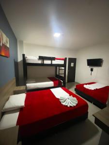 a bedroom with two bunk beds and a television at Hotel America 52 in Rionegro