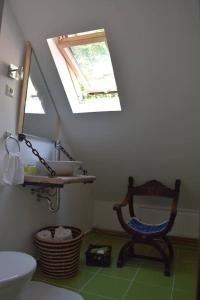 a bathroom with a chair and a sink and a mirror at Paloc Manor Vendeghaz Nagyvisnyo Romantic Heritage Guesthouse on the creek Nagyvisnyo in Nagyvisnyó