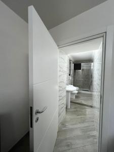 La salle de bains blanche est pourvue de toilettes et d'un lavabo. dans l'établissement MareLuna Gradoni di Chiaia, à Naples