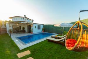 un patio trasero con un columpio y una piscina en Villa Star, en Fethiye