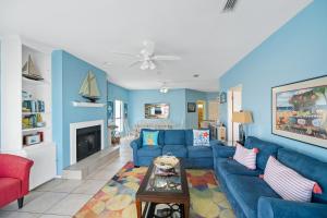 ein Wohnzimmer mit blauen Wänden und einem blauen Sofa in der Unterkunft La De Da in Gulf Shores