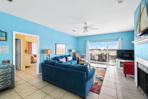 ein blaues Wohnzimmer mit einem Sofa und einem TV in der Unterkunft La De Da in Gulf Shores