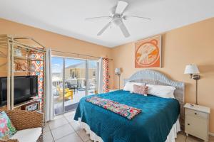 Schlafzimmer mit einem Bett, einem TV und einem Balkon in der Unterkunft La De Da in Gulf Shores