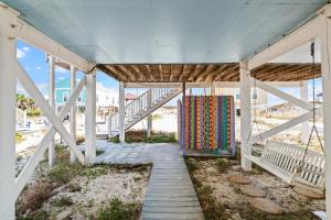 einen Holzsteg, der zu einem Strandhaus mit einer Treppe führt in der Unterkunft La De Da in Gulf Shores