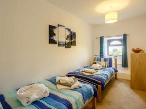 2 letti in una camera con strisce blu e bianche di 4 Bed in Cowling 84040 a Cowling