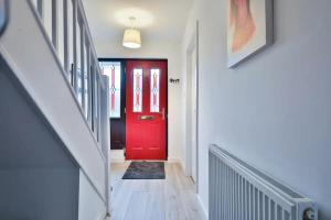 a red door in a hallway with a staircase at Eco Home for Large Groups w/ FREE Parking & Wi-Fi in Bristol