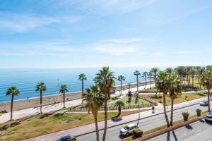 una calle con palmeras y el océano en el fondo en Special Mcgomez next to the beach, en Málaga