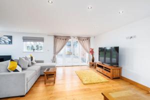a living room with a couch and a tv at Oak Cottage, HS2, NEC, BHX, M42, Family Gatherings, Contractors, Relocators in Birmingham