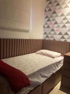 1 cama en un dormitorio con una pared geométrica en Casa completa e confortável en Leopoldina