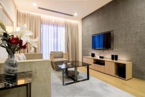 a living room with a couch and a tv at 188 Suites klcc by Luxe suites in Kuala Lumpur