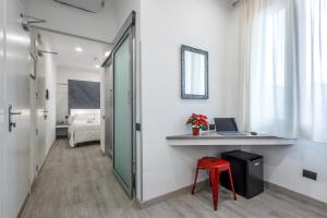 um quarto com uma secretária com um computador portátil e um banco vermelho em Crossroad Hotel em Roma