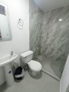 a bathroom with a shower and a toilet and a sink at CASA HOTEL YEMI in Barranquilla
