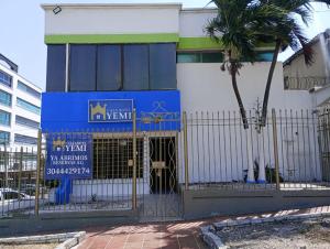 un bâtiment avec un portail et un palmier dans l'établissement CASA HOTEL YEMI, à Barranquilla