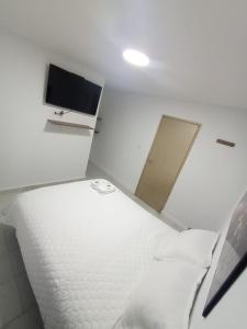 Habitación con cama y TV de pantalla plana. en CASA HOTEL YEMI, en Barranquilla