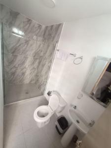 a bathroom with a toilet and a shower and a sink at CASA HOTEL YEMI in Barranquilla