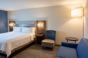 a hotel room with a bed and a chair at Holiday Inn Express & Suites Sioux City-South, an IHG Hotel in Sioux City