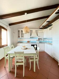 cocina con mesa blanca y sillas blancas en EdelBlu - Breathtaking seaview penthouse, en Castelsardo