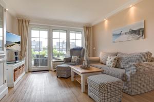 ein Wohnzimmer mit einer Couch und einem Tisch in der Unterkunft Landhaus Westerhörn, Sölring Tir, App. 1 in Wenningstedt-Braderup
