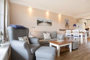 ein Wohnzimmer mit einer Couch und einem Tisch in der Unterkunft Landhaus Westerhörn, Sölring Tir, App. 1 in Wenningstedt-Braderup + 28 Fotos