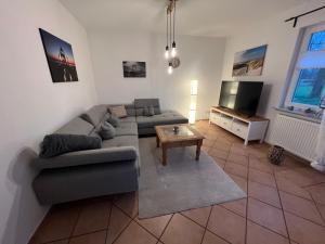 een woonkamer met een bank en een tv bij Weideblick in Upgant-Schott