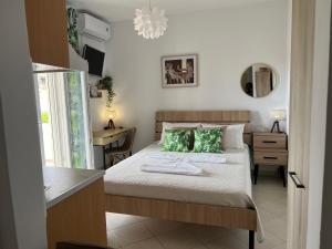 a bedroom with a bed with green pillows and a desk at Actis studios 1 in Stelida